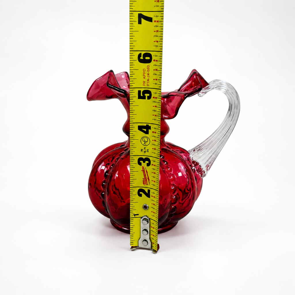 Fenton Art Glass cranberry pitcher featuring molded melon pattern and clear handle