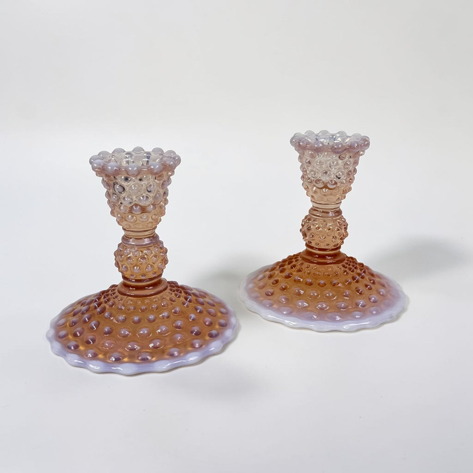 Pair of pink hobnail glass candle holders with scalloped bases