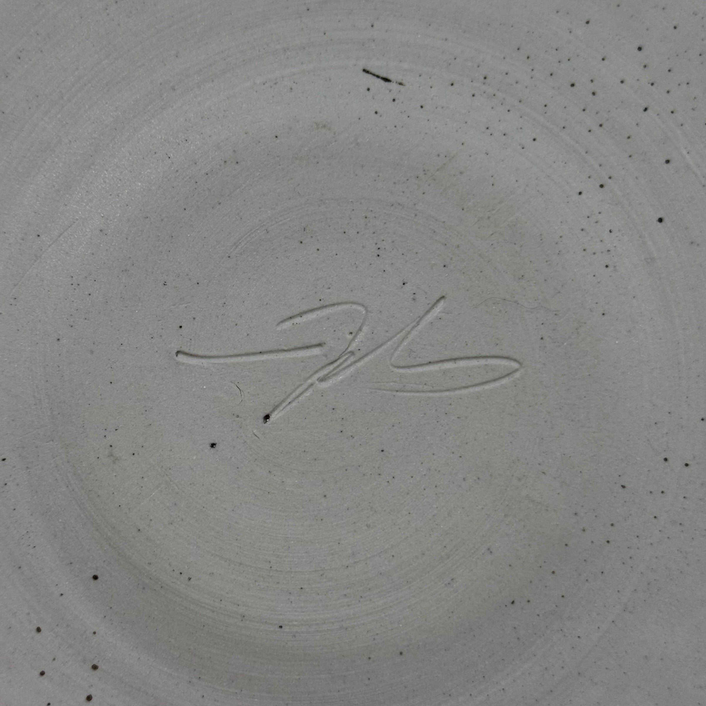 Signature on a textured gray surface