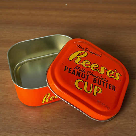Reese's Peanut Butter Cup tin on a wooden surface